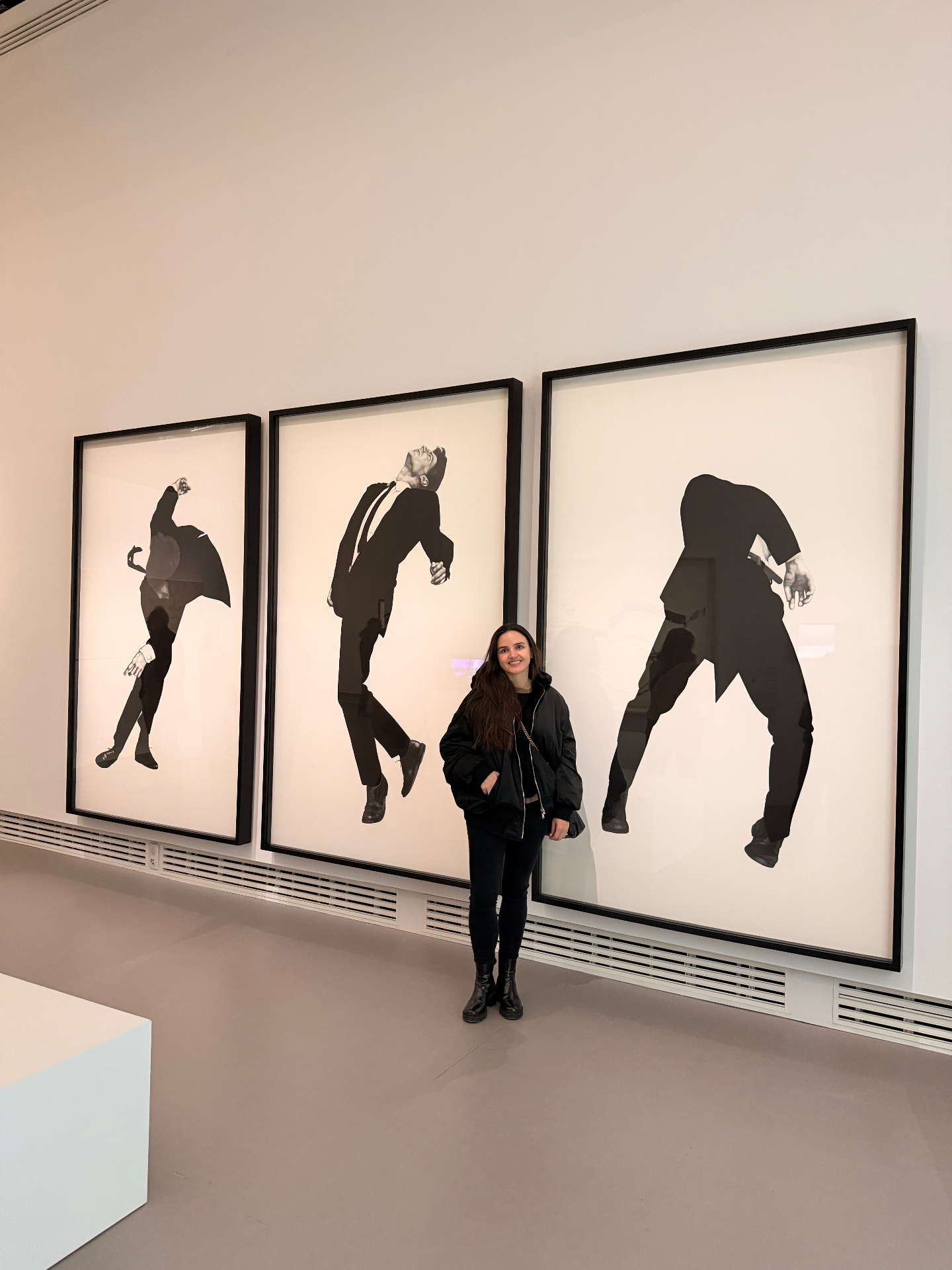 Karol in front of a triptych of black figurative works
